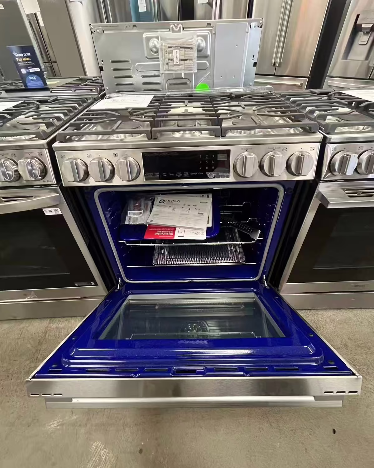 A stainless gas range with its oven door open