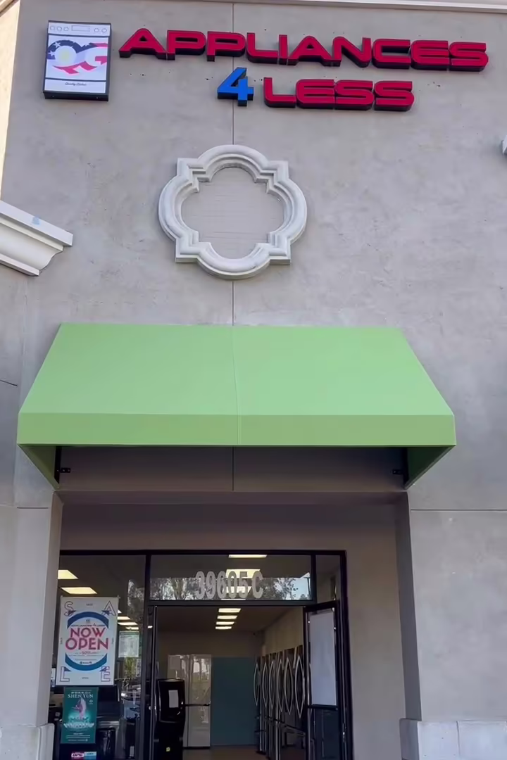 The Appliances 4 Less entrance under its sign and green awning in the Murrieta Gateway Center